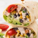 A chicken salad wrap cut in half and stacked on top of each other with a toothpick.