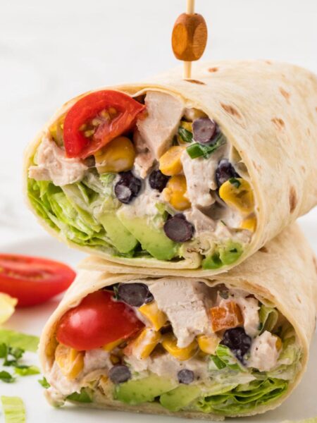 A chicken salad wrap cut in half and stacked on top of each other with a toothpick.