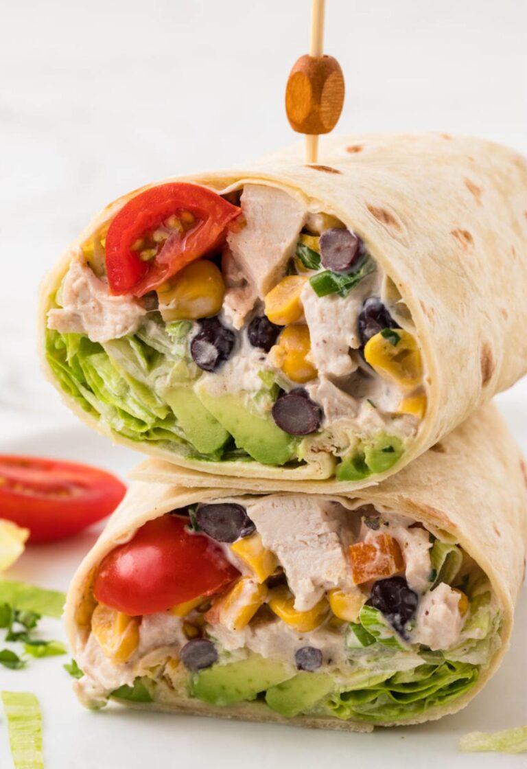 A chicken salad wrap cut in half and stacked on top of each other with a toothpick.