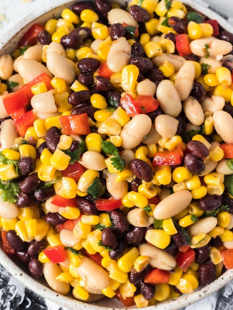 Overhead shot of black bean salad with corn inside a white bowl. 