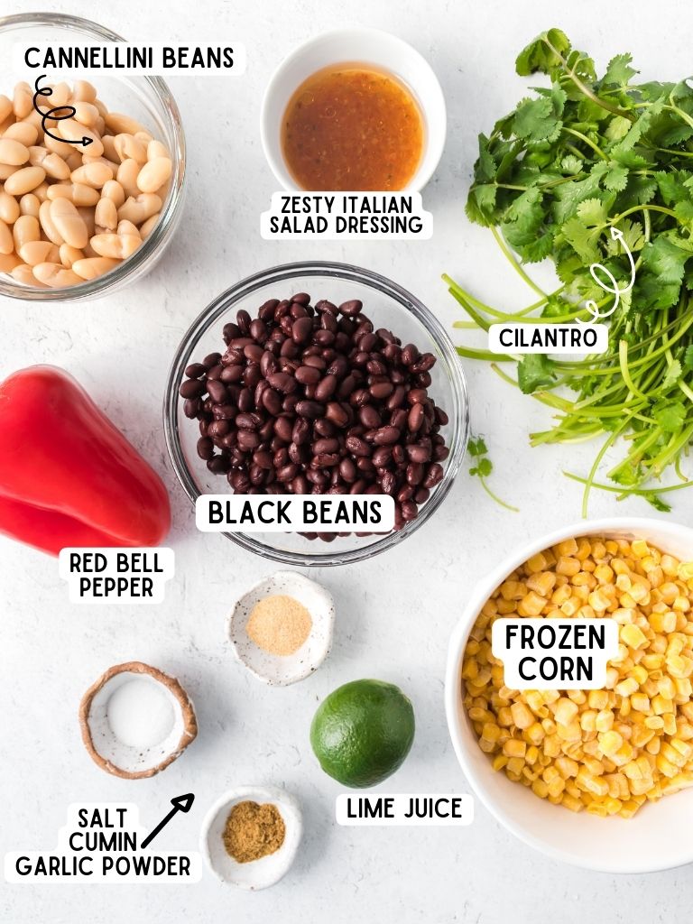 Ingredients needed to make this black bean corn salad with each one labeled in black text with the name of it. 