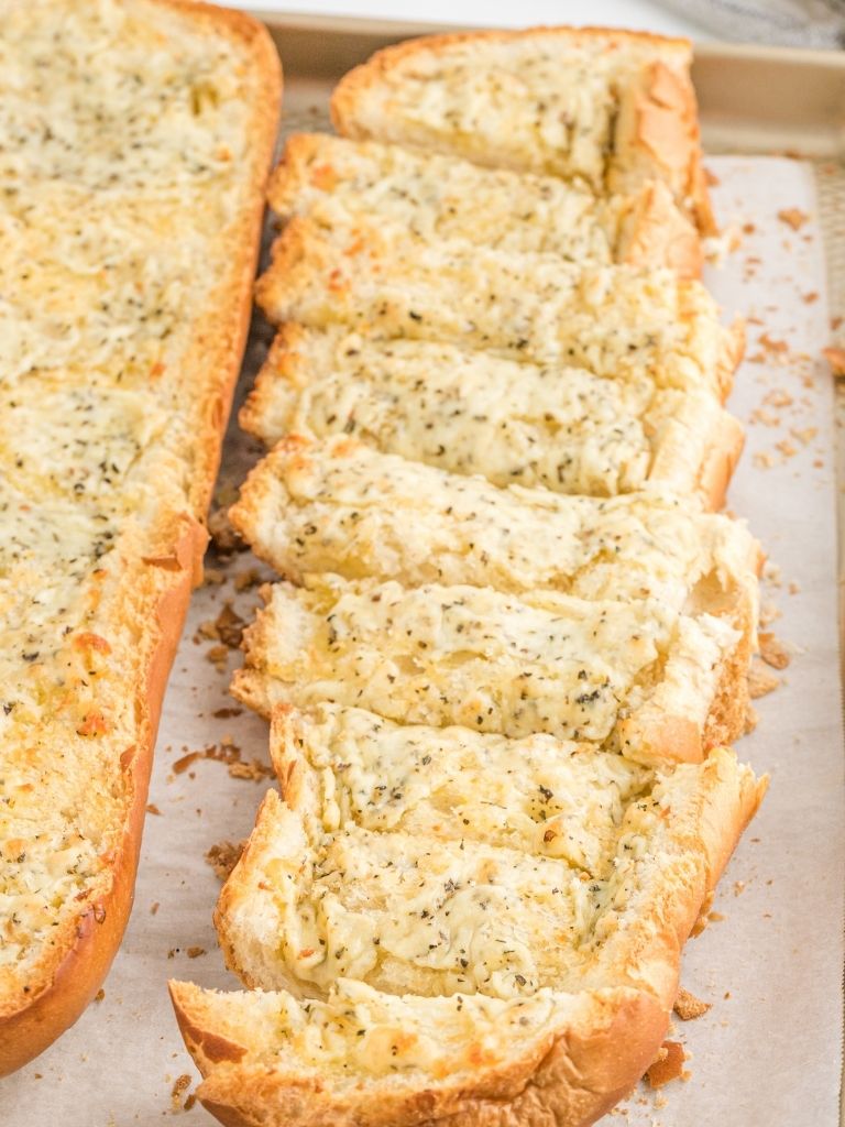 French bread loaf cooked with garlic butter. With one side sliced and the other side whole. 