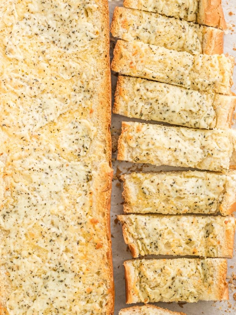 garlic bread halves on a cookie sheet baked in the oven.