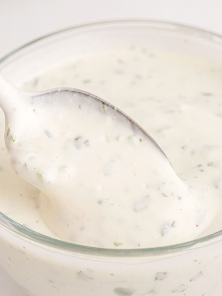 Close up shot of ranch up recipe with a spoon inside of the dish. 