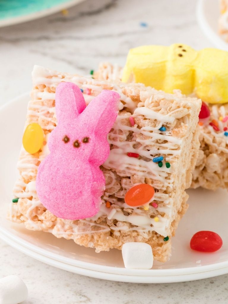 Krispie treats for easter on a white plate with one facing forward to show the front of it.