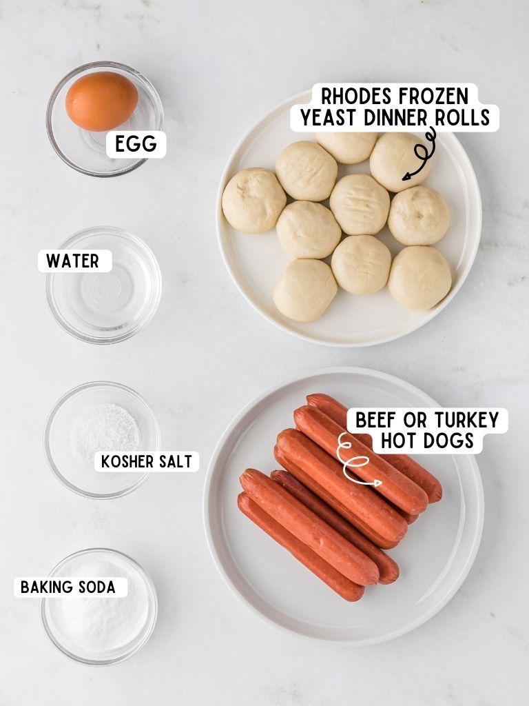 Ingredients needed to make hot dogs with pretzel on the outside with each one labeled in black text with the name of it. 