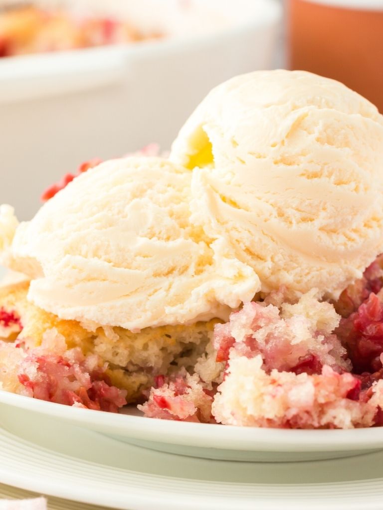 A white bowl with cobbler inside of it and ice cream.