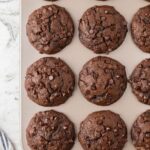 A muffin tin with baked zucchini muffins in it.