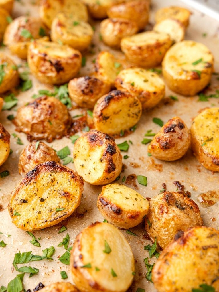 A tray of roasted potatoes with parsley 