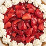 A strawberry pie inside a pie plate with a graham cracker crust.