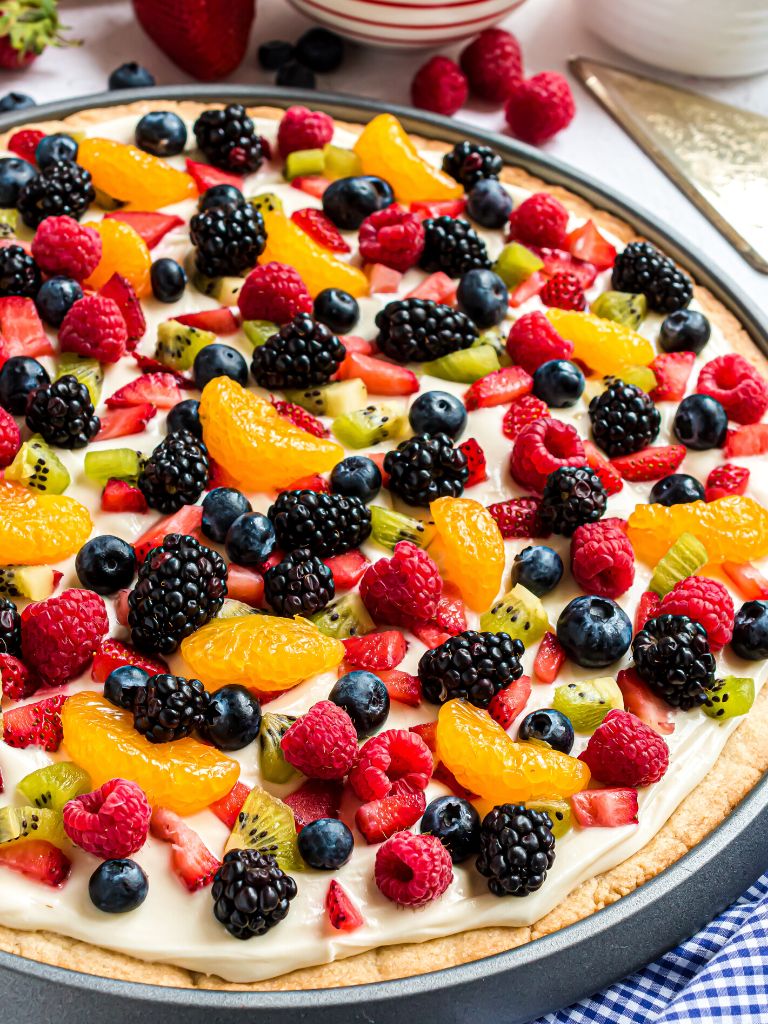 A side view of a fruit pizza on a pizza pan. 