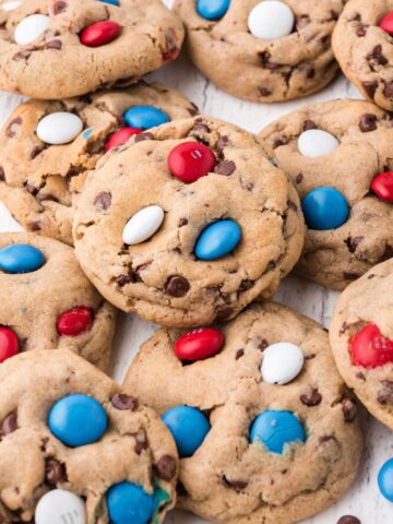Close up shot of a bunch of cookies with patriotic mix m&m's on them.