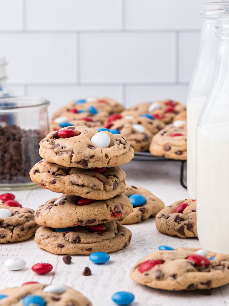 Stack of cookies with a glass of milk next to it.