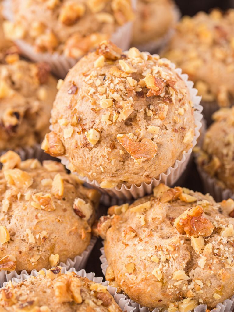 Muffins stacked together with the walnuts showing on top. 