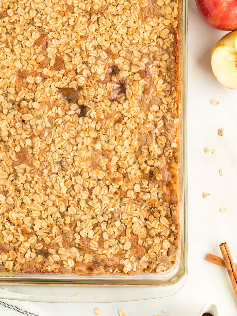 A baking pan of a dump cake with pie filling and a cake mix and oat topping. 
