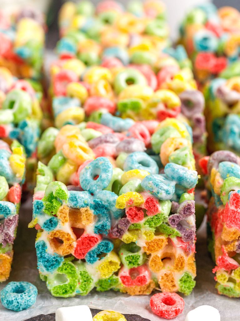 Close photo of cereal bars with cereal pieces and marshmallows at the side of it. 