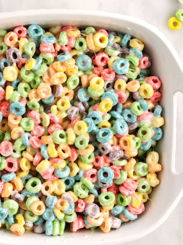 A white dish of cereal treats with Froot Loops cereal. 