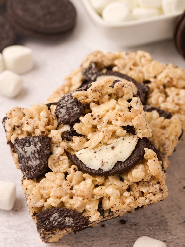 A Rice Krispie treat with oreo cookies that are chopped on top of it. 