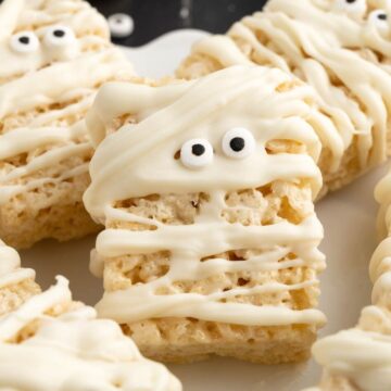 Rice Krispie treat squares made to look like mummy with white chocolate and candy eyes.