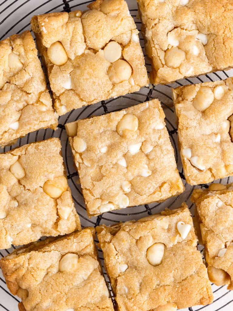 Overhead shot of cookie bars cut into squares against a wire rack below it. 