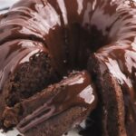 A chocolate Bundt Cake with a cake mix and a brownie mix sitting on a white plate.