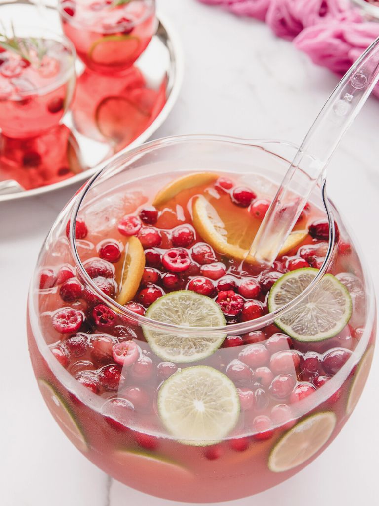 A punch bowl with a tray of drinks next to it. 