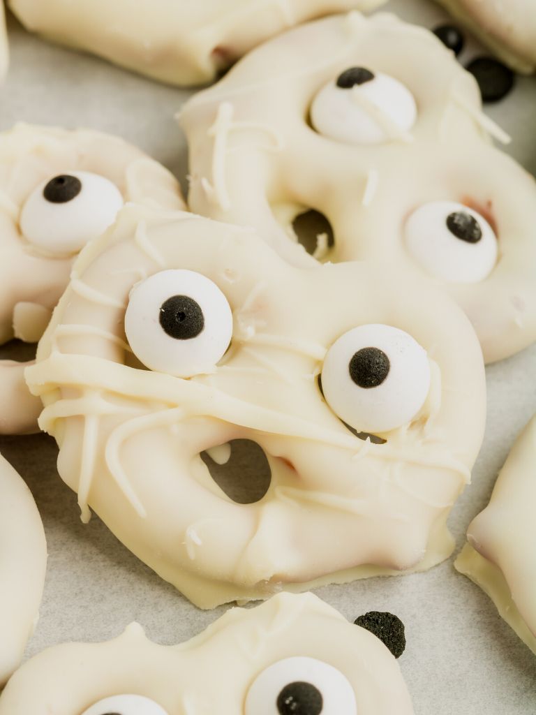 A close up of a dipped pretzels made to look like a ghost.