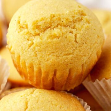 cornbread muffins inside a basket lined with a white towel.