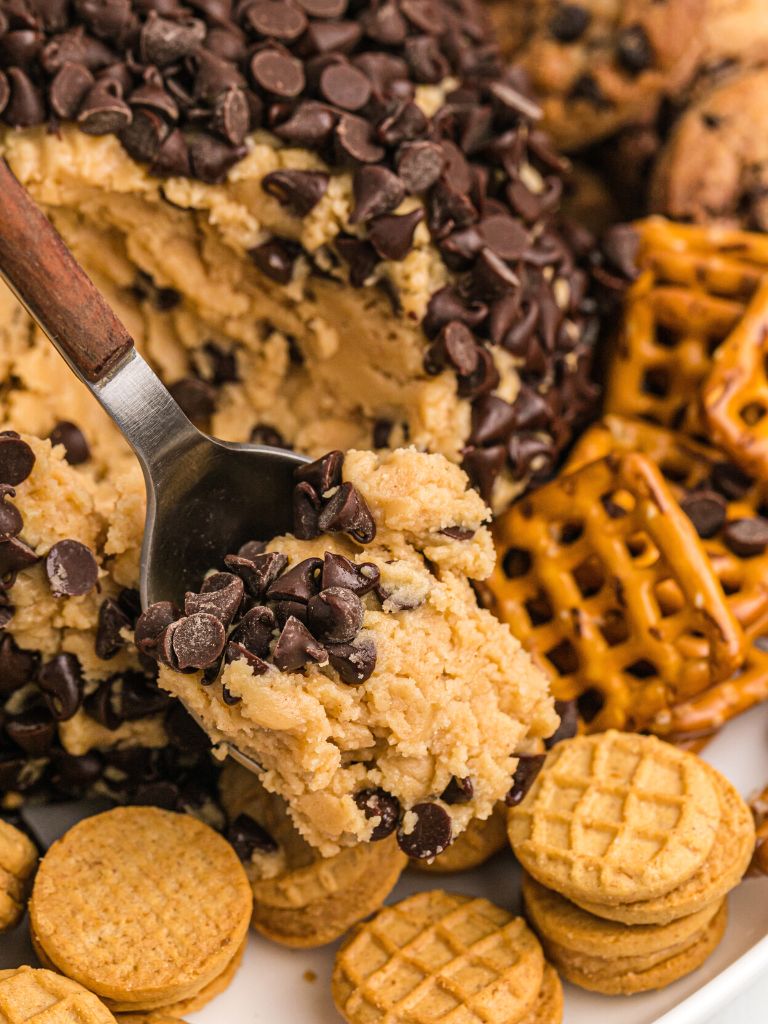 A spoon with edible cookie dough on it.