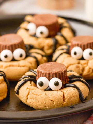 A black plate of cookies that look like spiders.