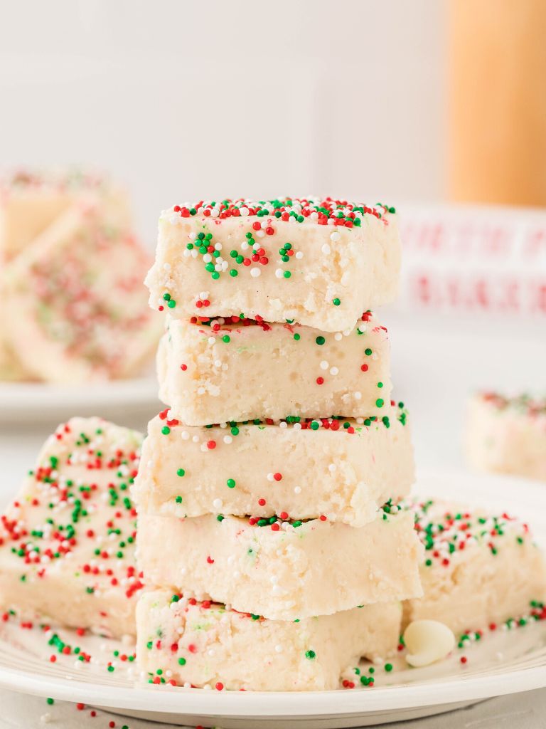 A stack of fudge with red and green sprinkles on top. 