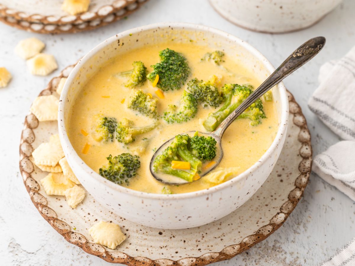 Horizontal photo of a bowl of soup with a spoon inside of it.
