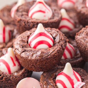 Stacks of brownie bites with a kiss on top, with some unwrapped kisses next to them.