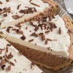 A pin tin with chocolate pie inside and piece cut out.