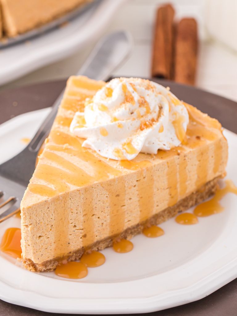 Slice of cheesecake with whipped cream and caramel.