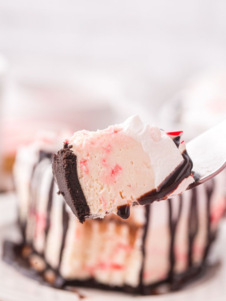 A photo of a pie with chocolate drizzle and peppermint candies. 