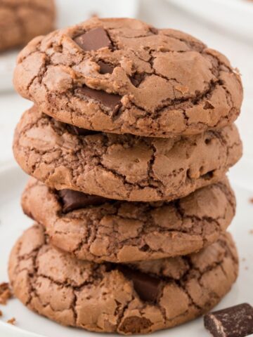 Stack of brownie cookies on a white plate.