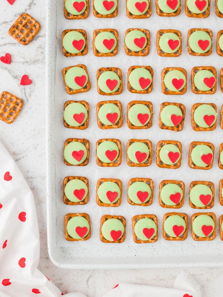 Rows of pretzel bites on a cookie sheet that look like the grinch. 