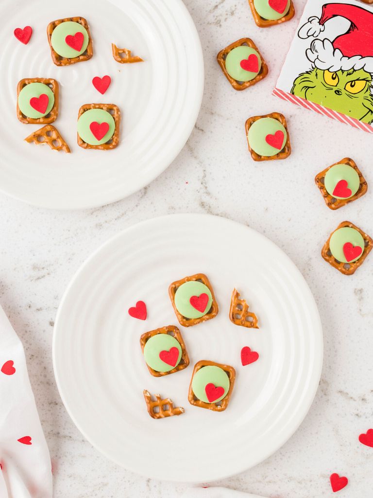 Grinch pictures with some pretzel bites on plates. 