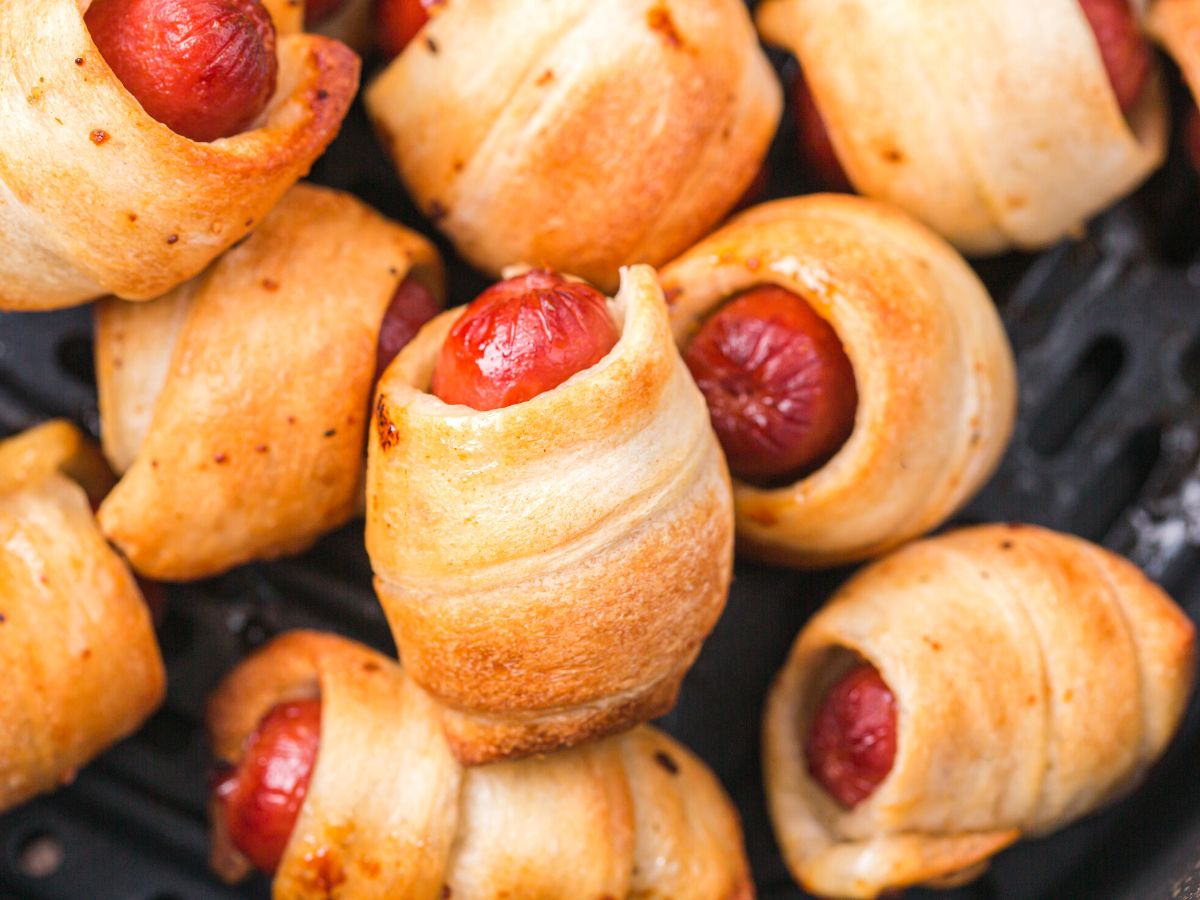 A close up photo of pigs in a blankets. 