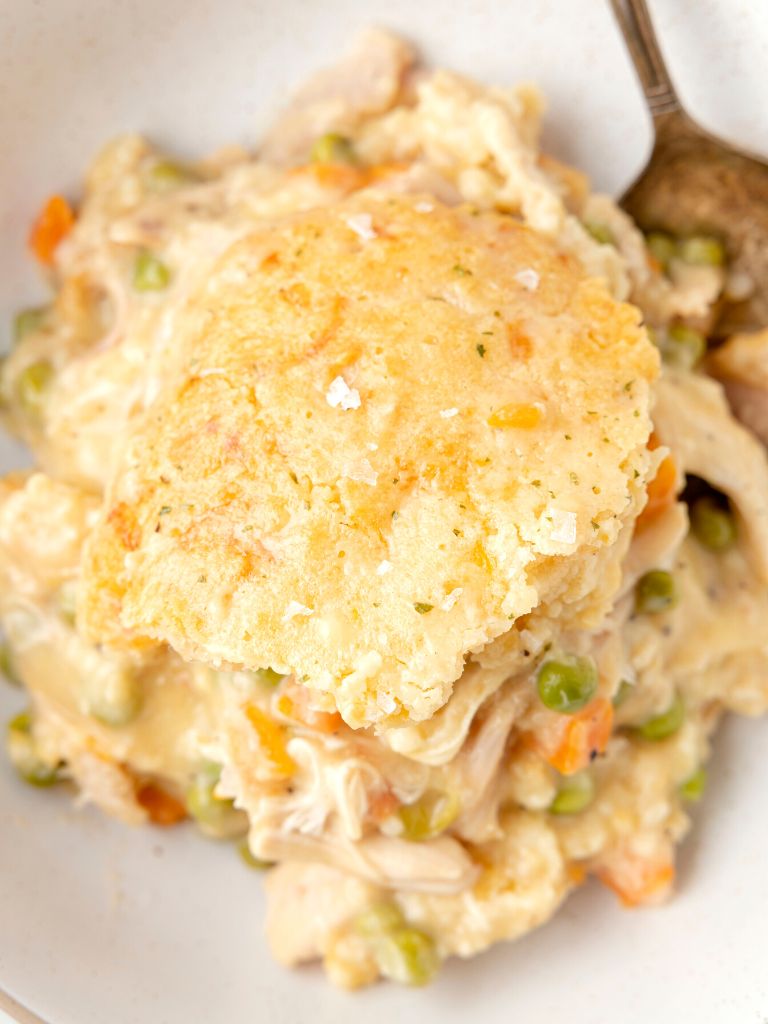 Overhead shot of this casserole recipe with a fork and sea salt flakes on top of the biscuit topping. 