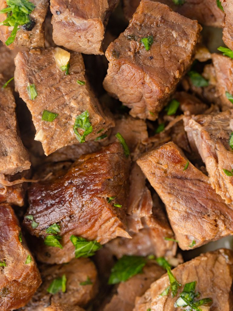Close up of steak cubes with parsley. 