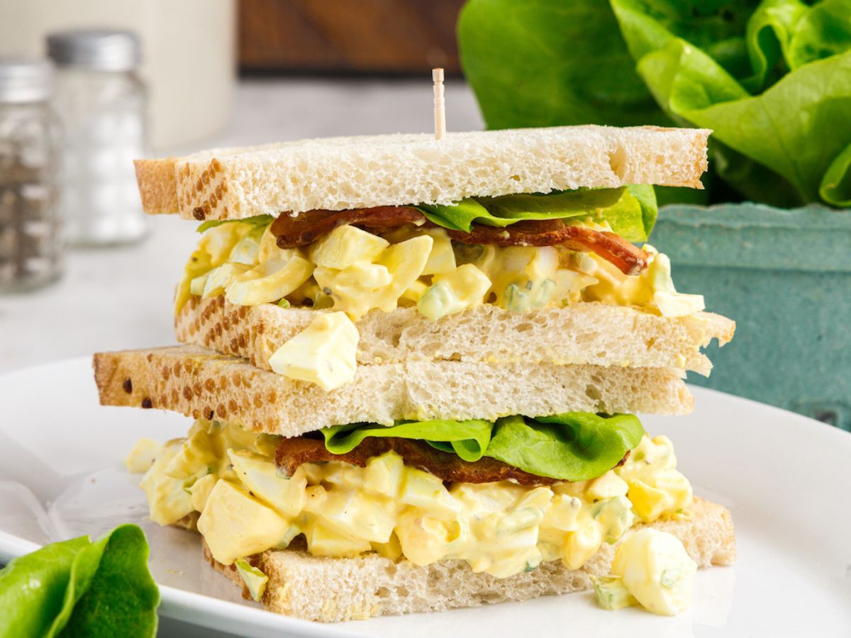 Step by step process photos showing how to make egg salad sandwich with the steps needed. 