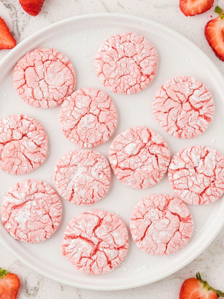 Overhead shot of a plate of cookies with strawberries to the side of the plate. 