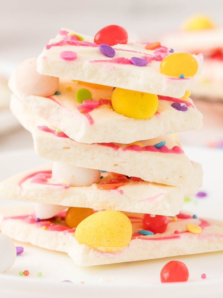 A stack of white chocolate bark with jelly beans on it and sprinkles. 