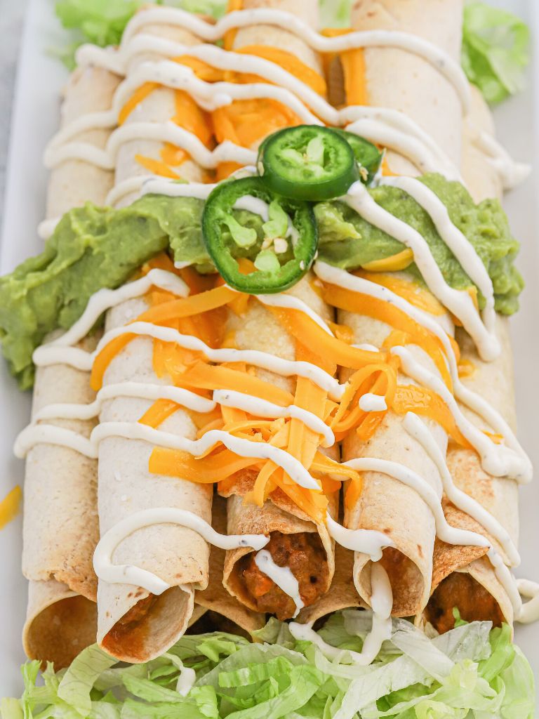 A stack of tortillas that have been baked and topped with lettuce, cheese, and jalapeños.