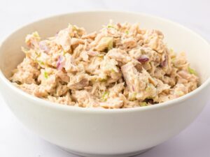A white bowl of tuna salad inside it.