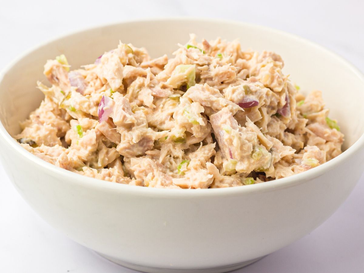A white bowl of tuna salad inside it. 