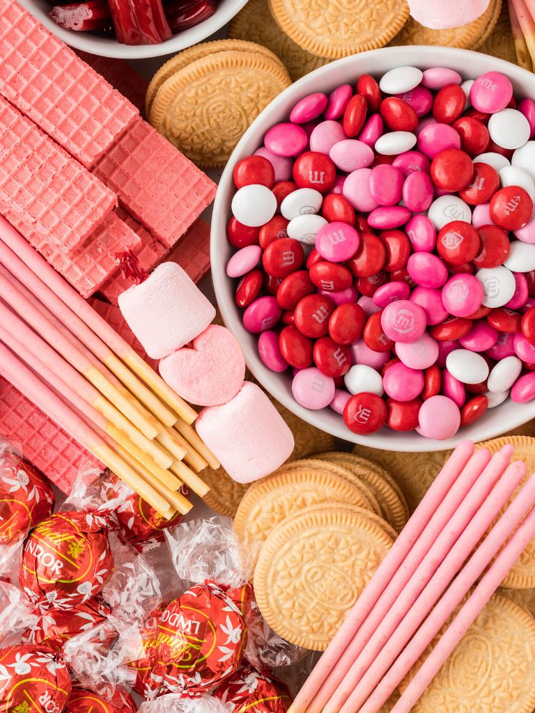 Close up picture of a dessert board with pink treats.