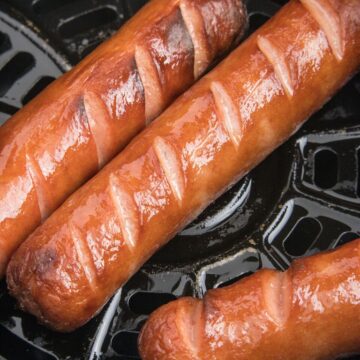 Hot dogs that are cooked inside the air fryer with slits on the top for the best cooking technique.